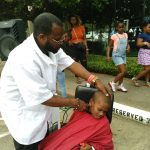 A man cutting the hair of a boy